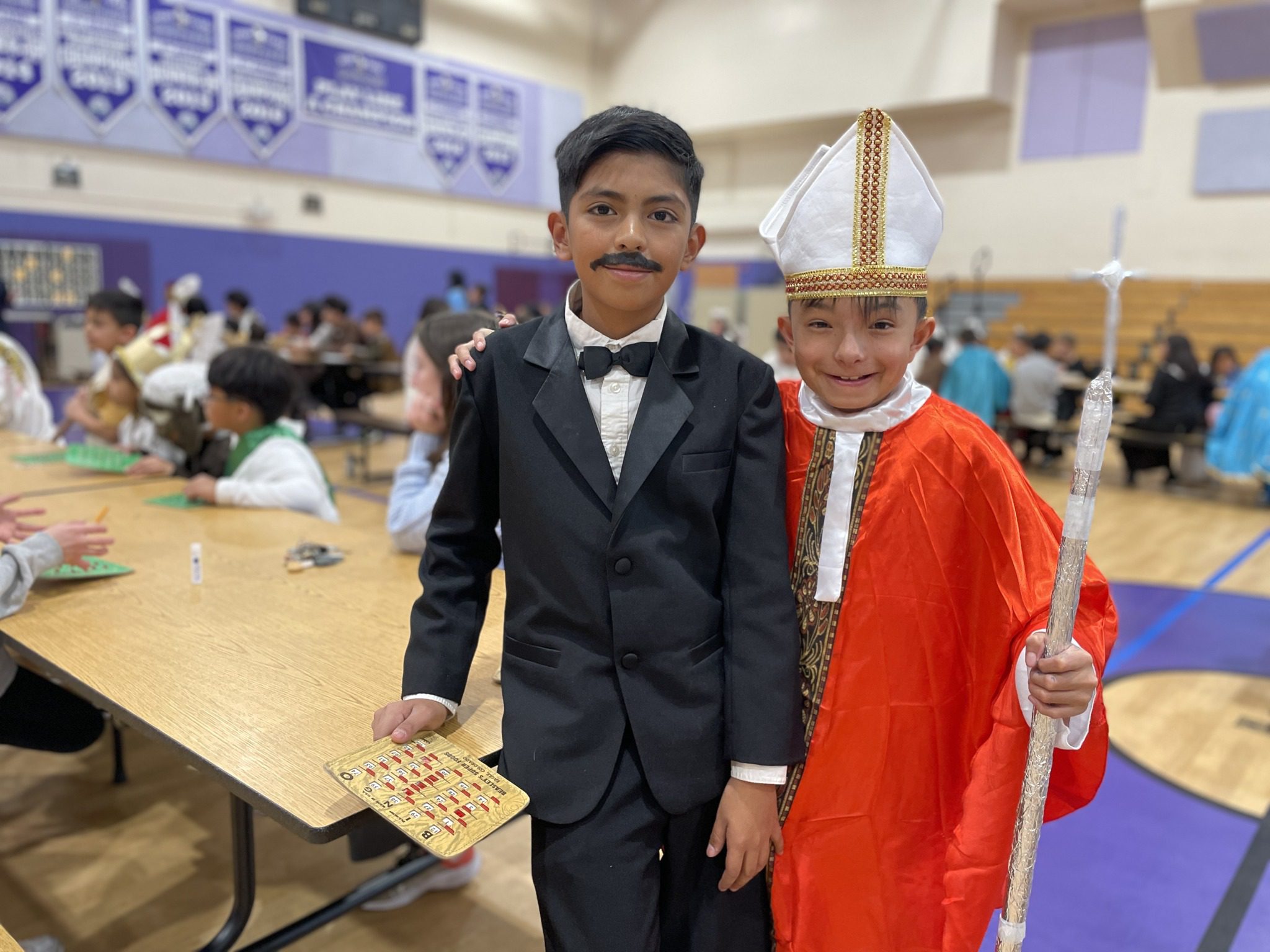 Two boys dressed in costumes at a school event.