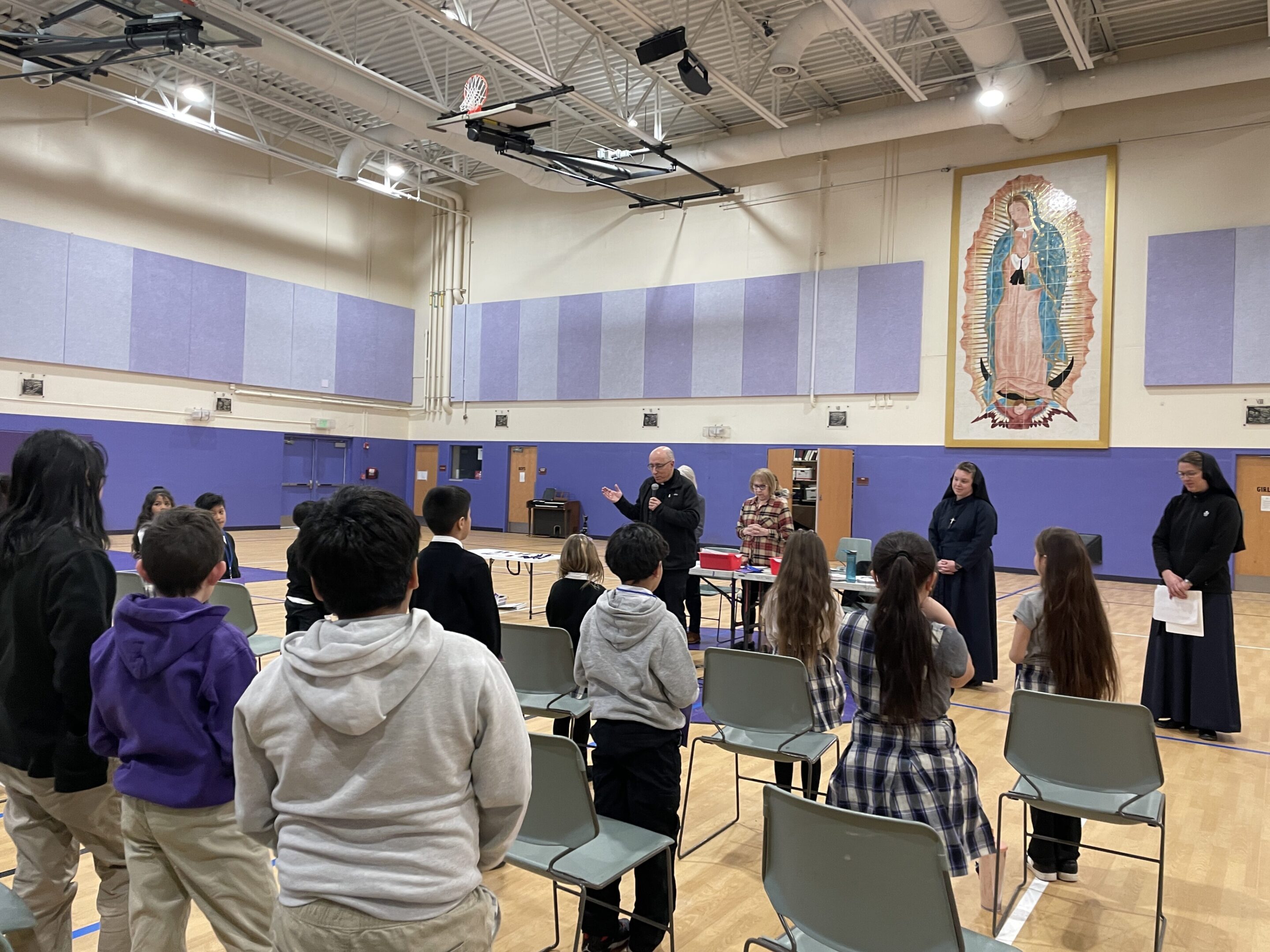 Students standing in a gymnasium during an assembly or event.
