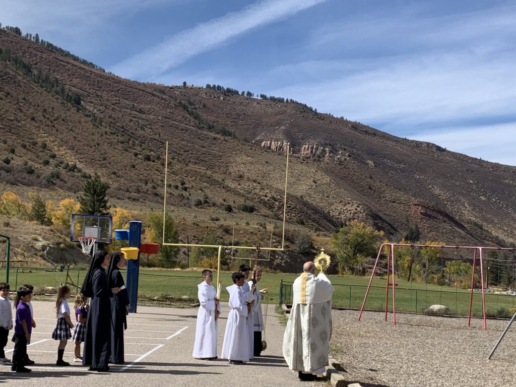 Religious ceremony taking place outdoors with a mountain backdrop.