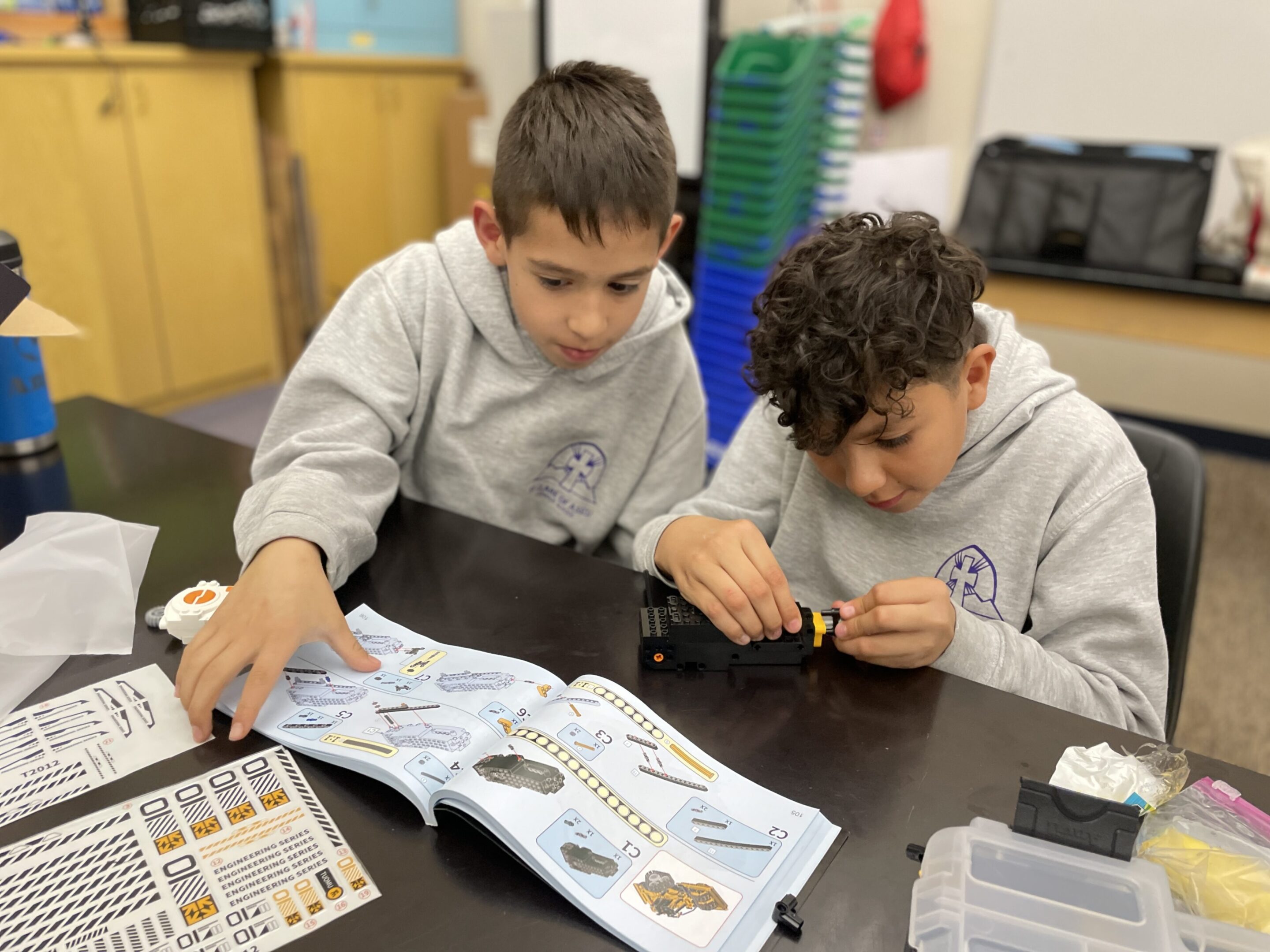 Two boys assembling a model kit together.
