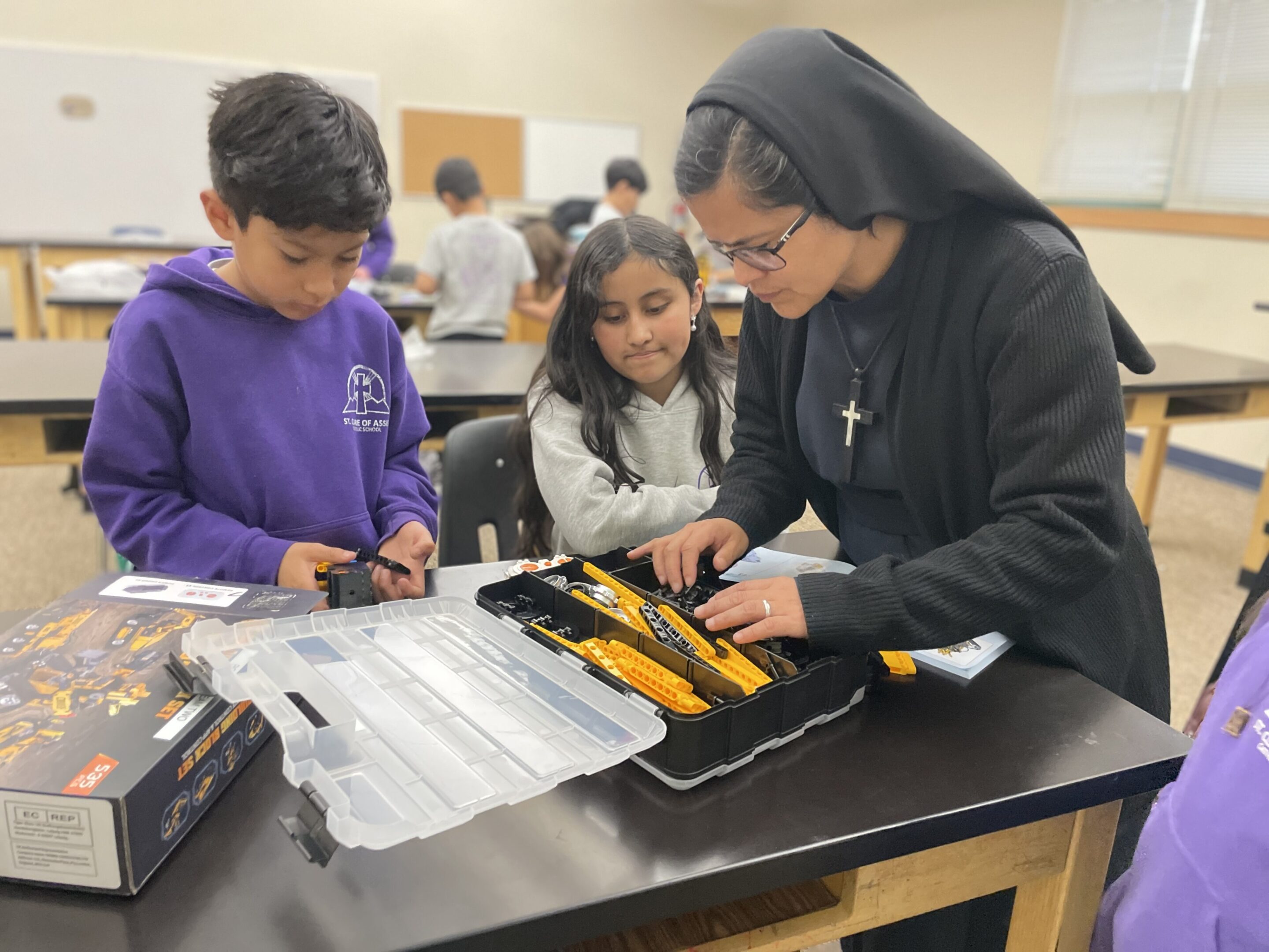 A nun assists two children with a science experiment in a classroom.