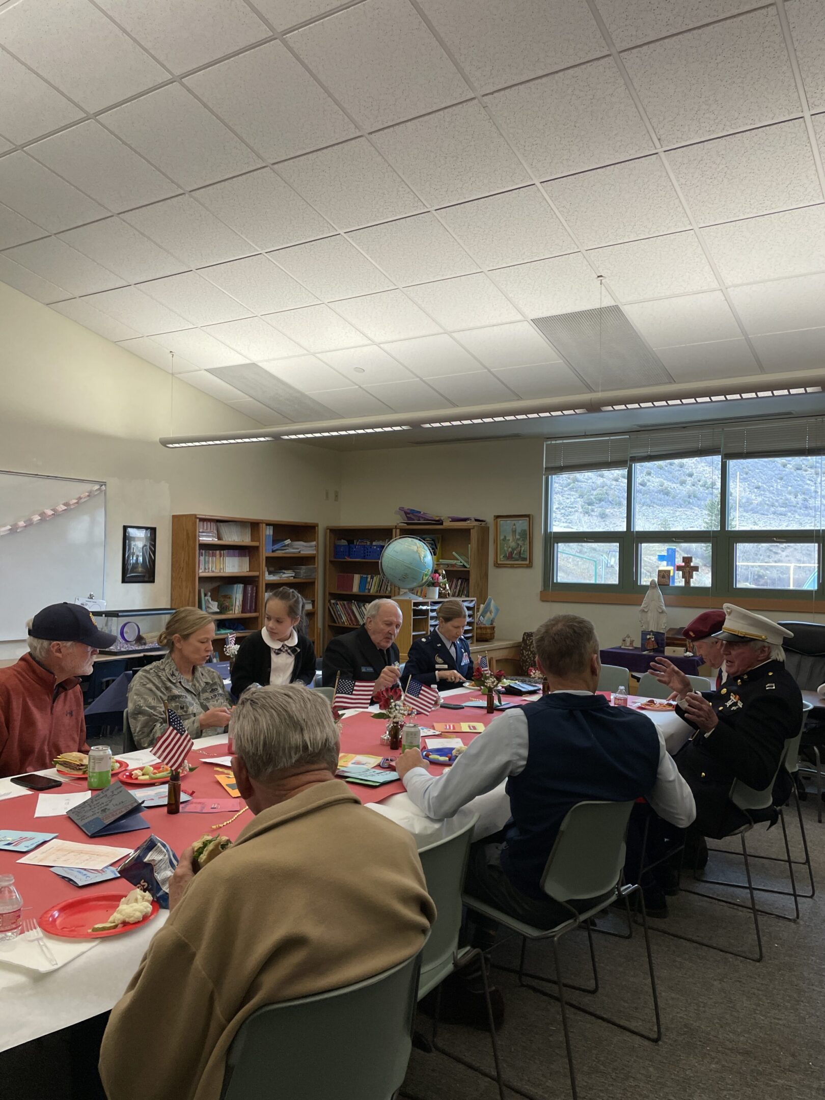 Students attentively participate in a classroom discussion around a table.