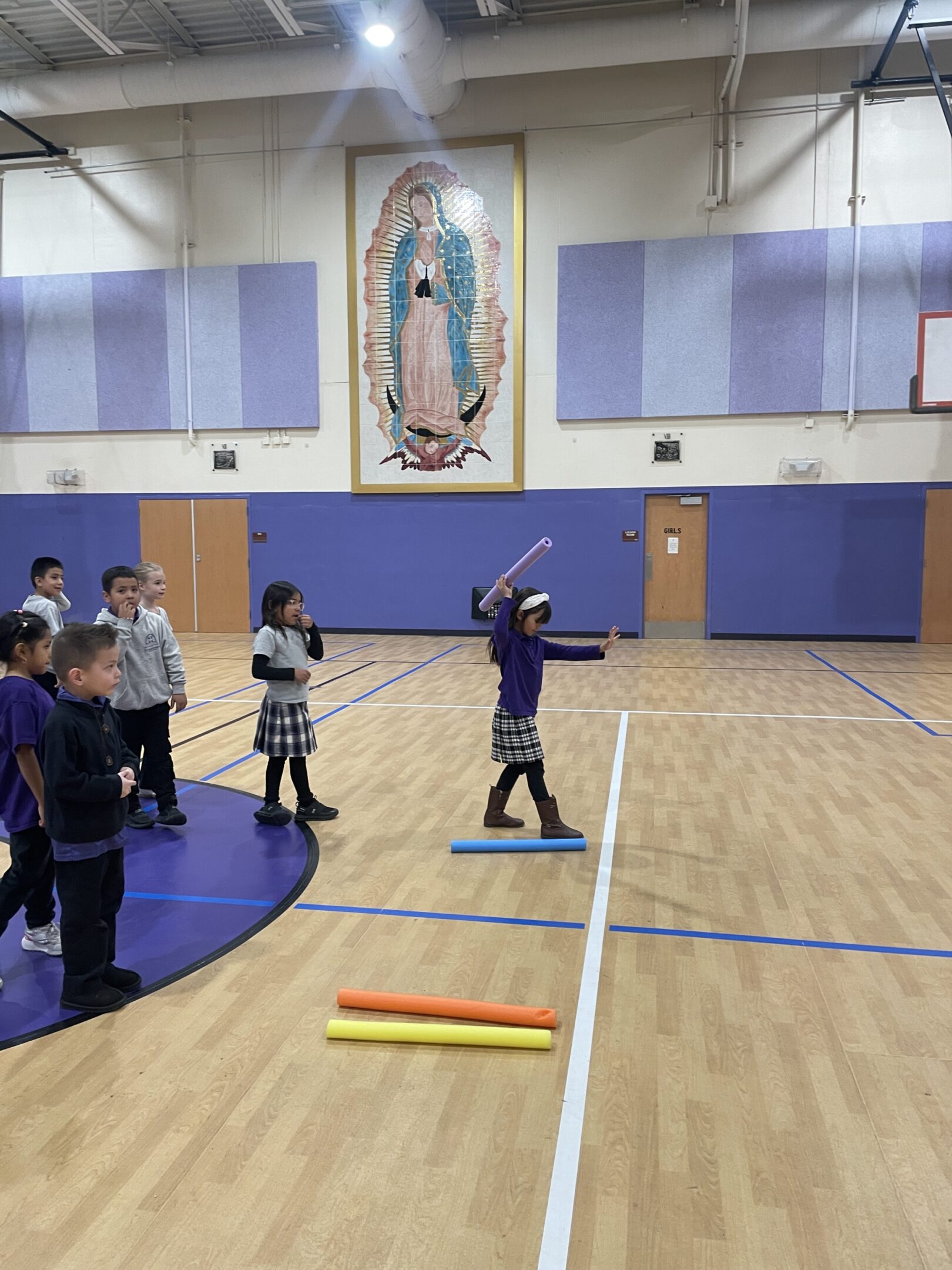 Children playing a game in a school gymnasium.