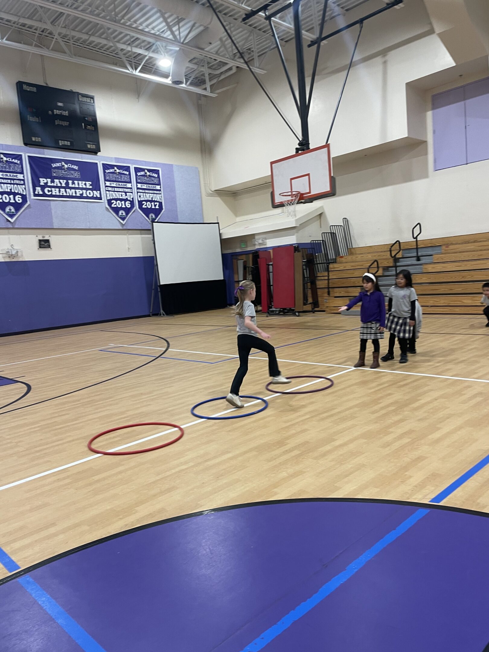 Children playing a basketball game in a gymnasium.