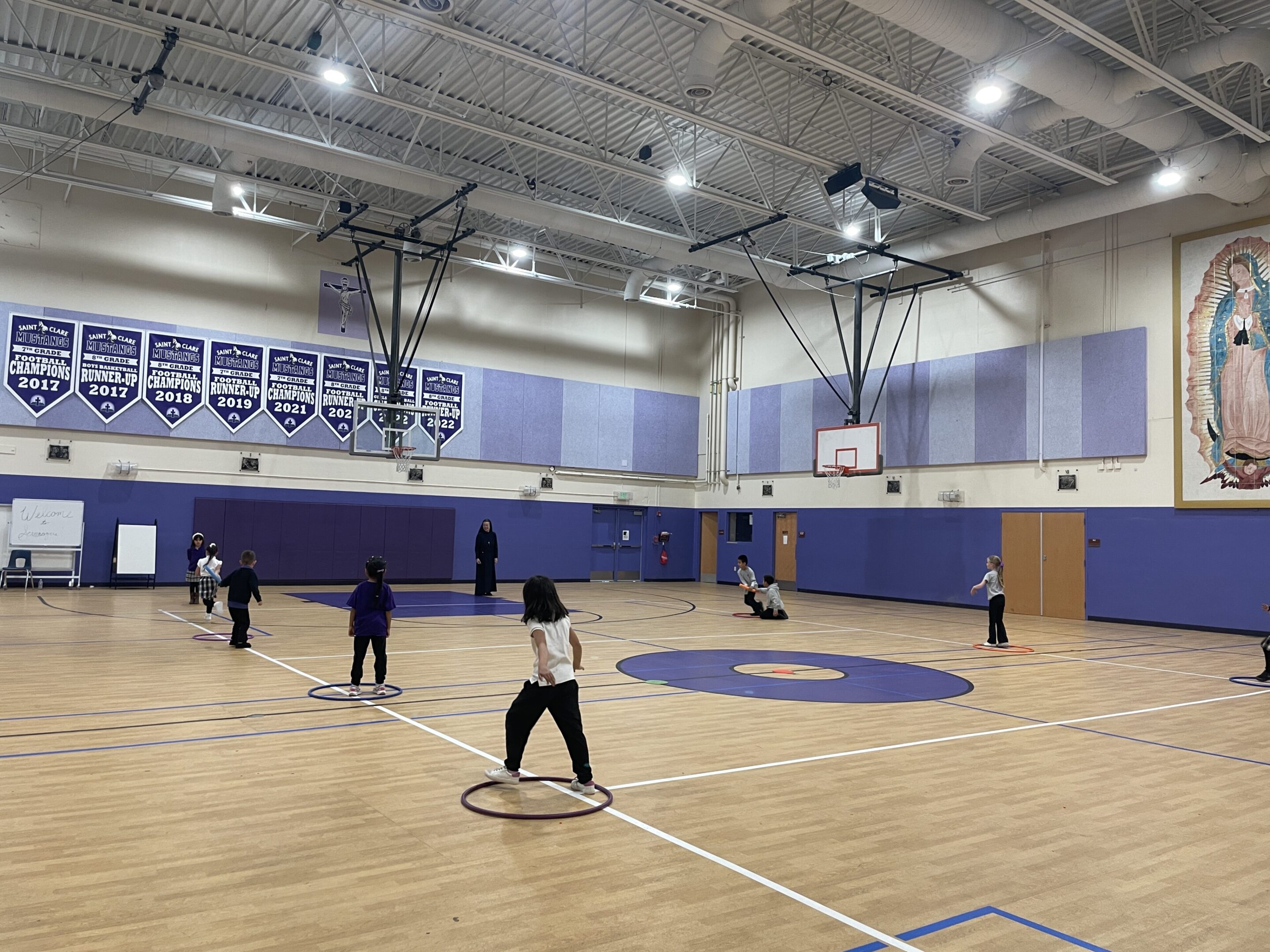 People playing basketball in an indoor gymnasium.