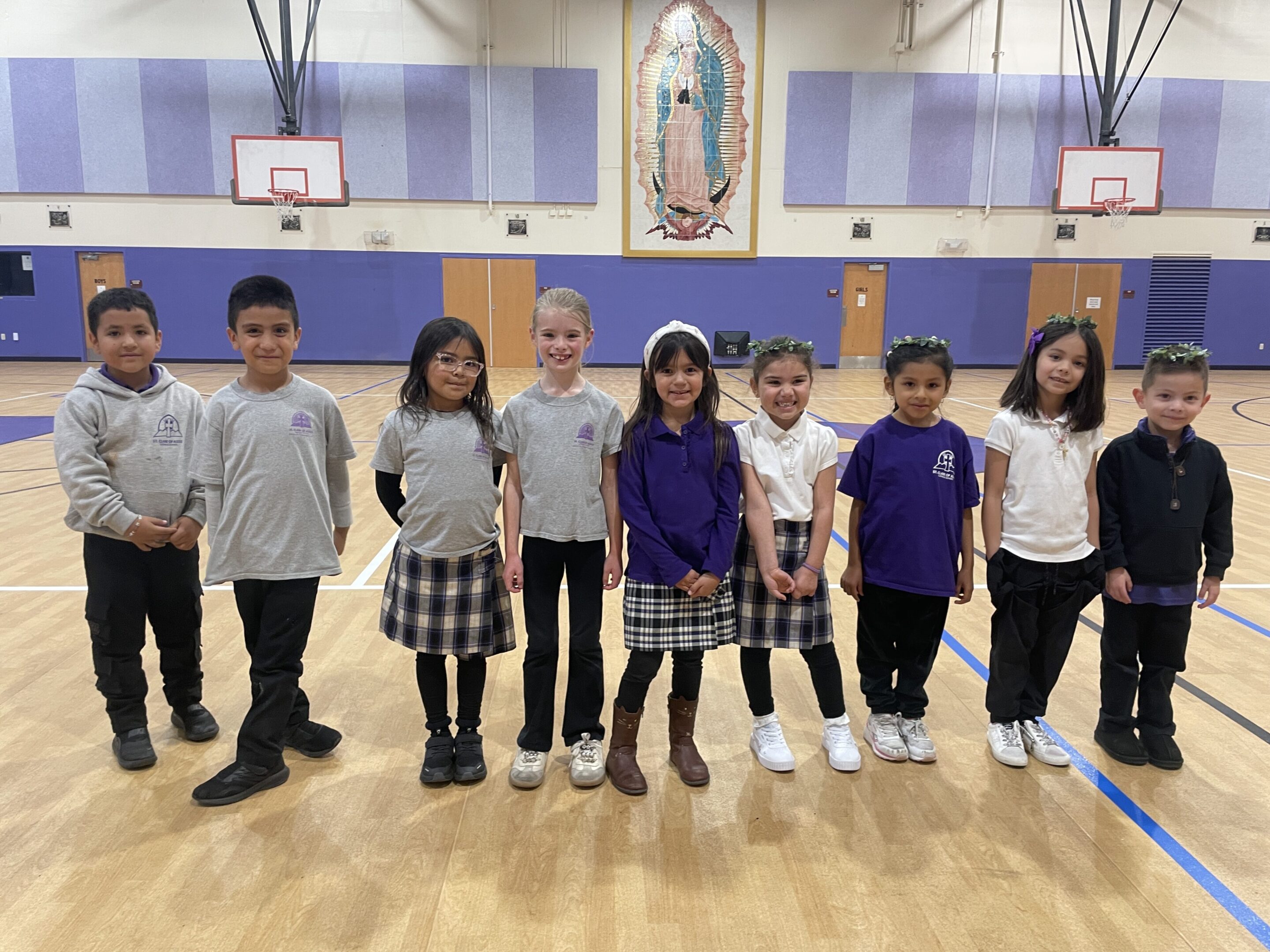 A group of six children standing in a gymnasium.