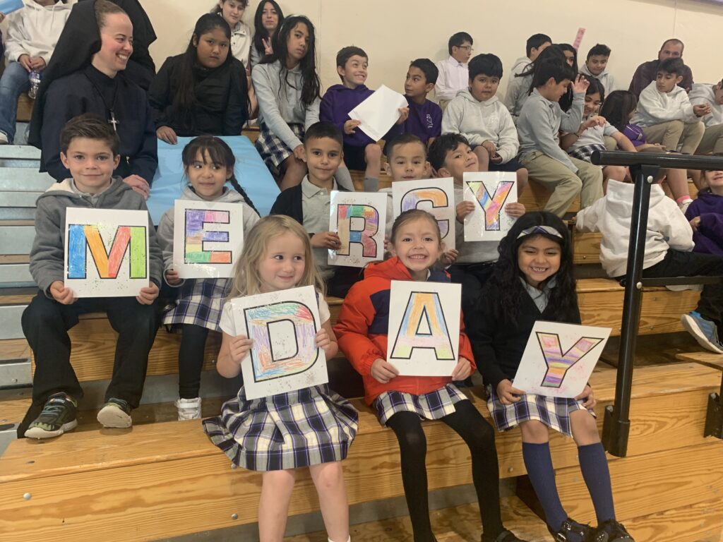 Children holding colorful letters spelling "Veterans Day" in a classroom setting.