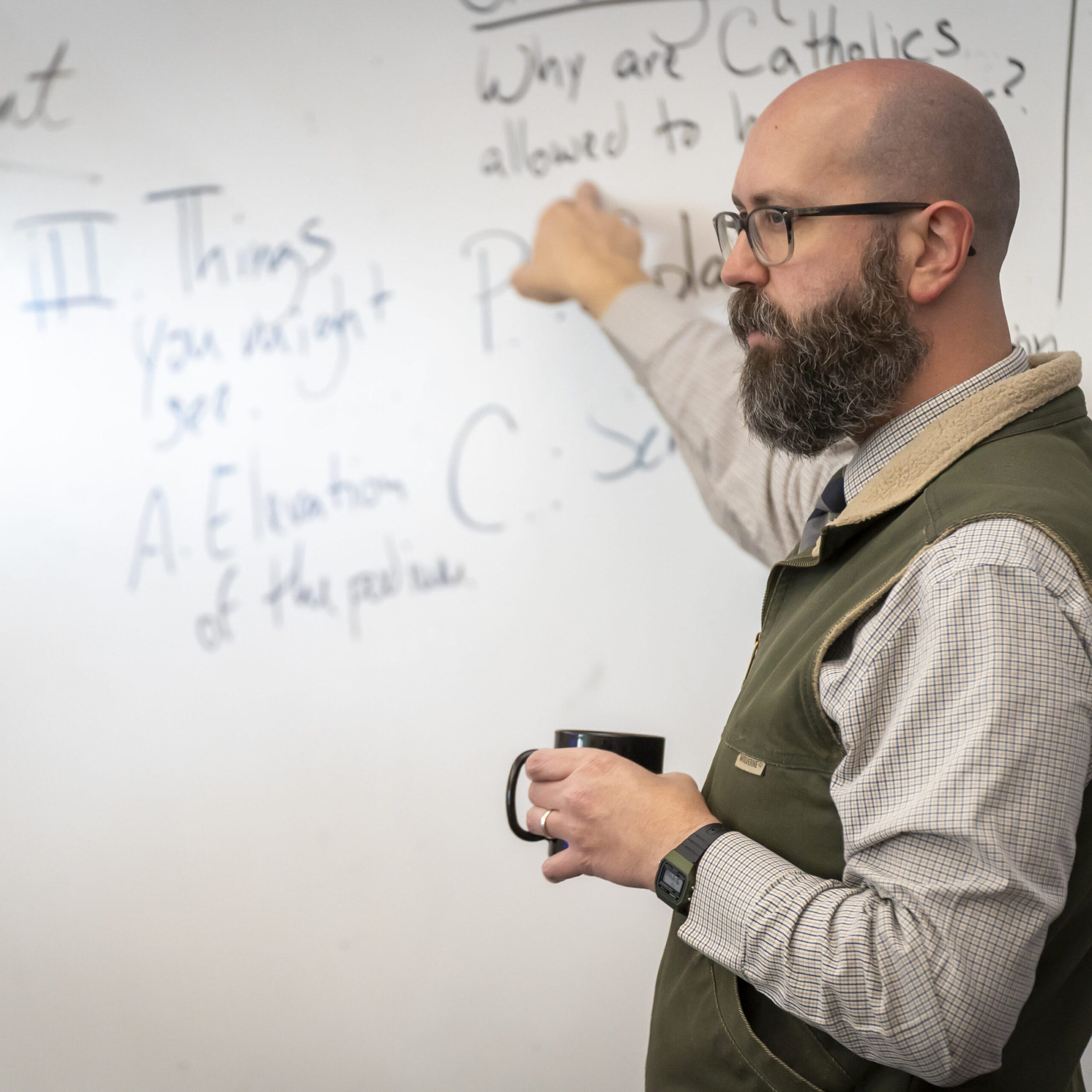 A man teaching and explaining concepts on a whiteboard.